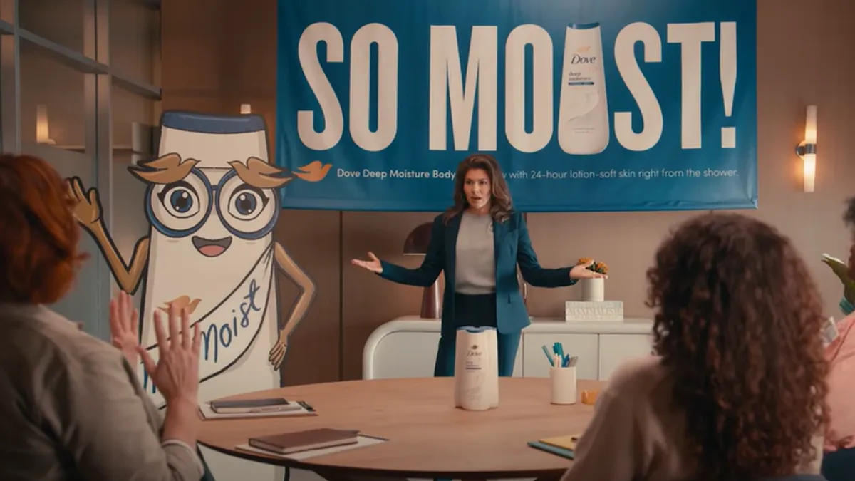 A group of women sitting at a table watch a presentation for Dove's new moist-themed mascot and advertising.