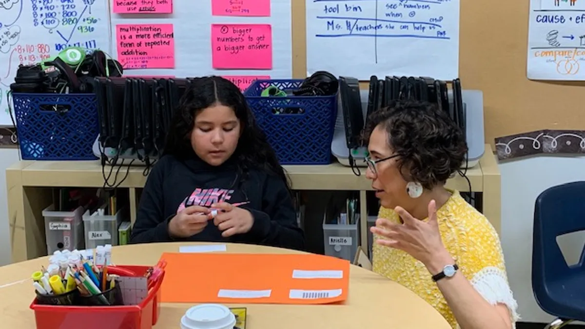 High Tech High Graduate School of Education apprentice Melina Aquirre works with a student on division assignment.