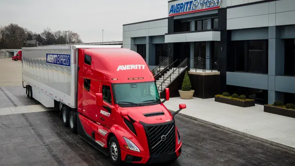 An Averitt Express tractor-trailer outside a building featuring the carrier's name and logo.