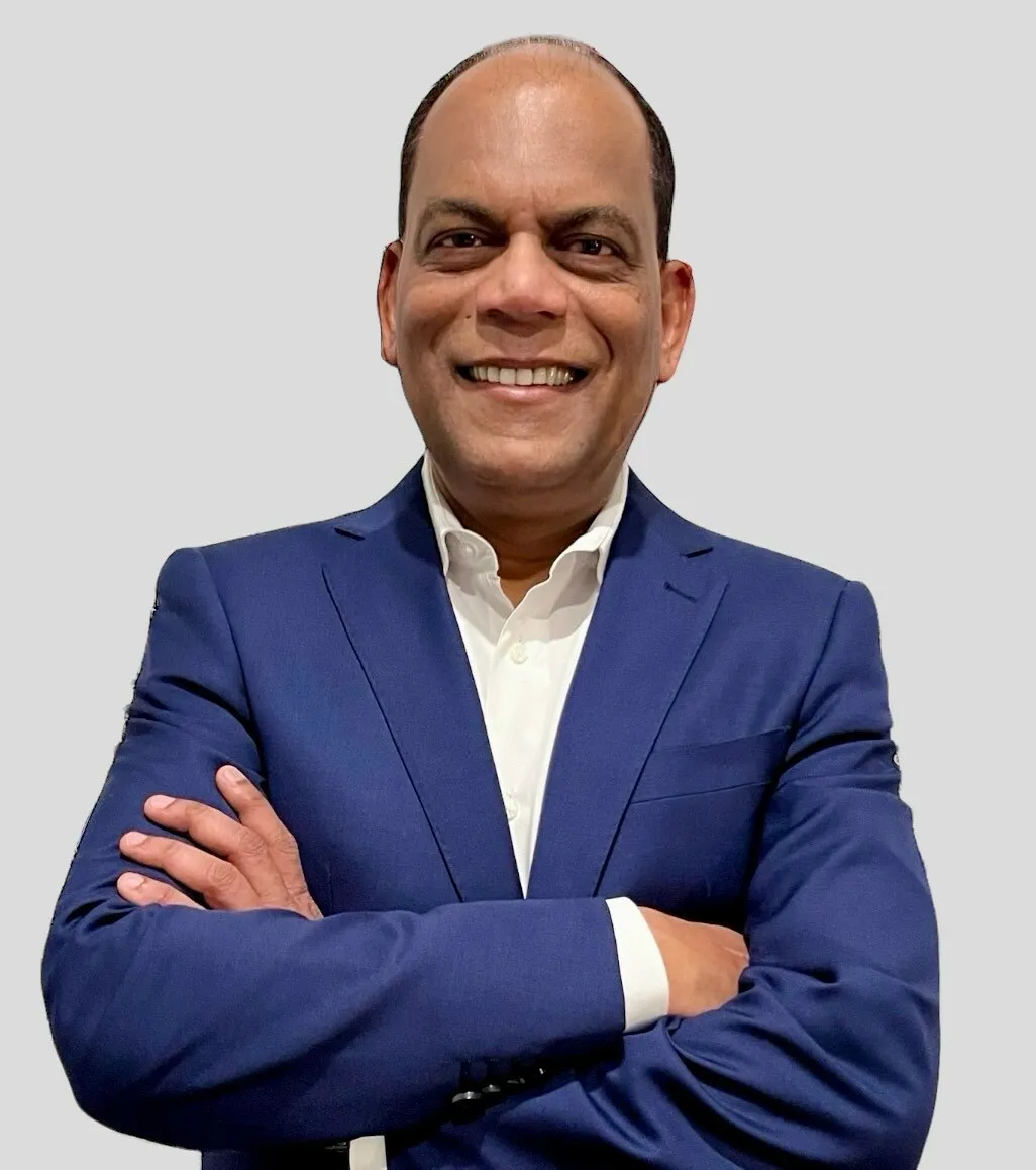 Headshot of a man in a suit standing with his arms crossed