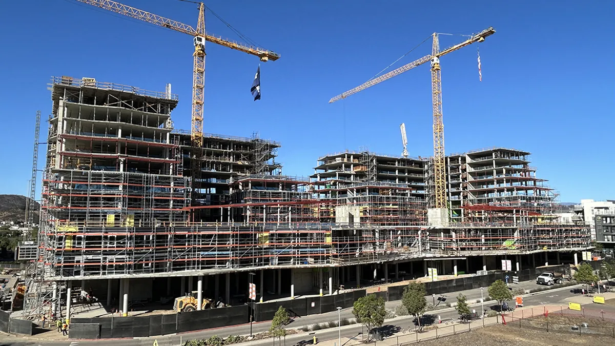 A building under construction rises on a street corner.