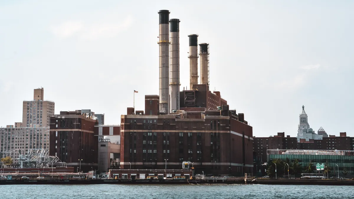 City skyline with industrial chimneys and office buildings, with river in the foreground