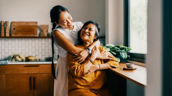 Two people embracing at home.