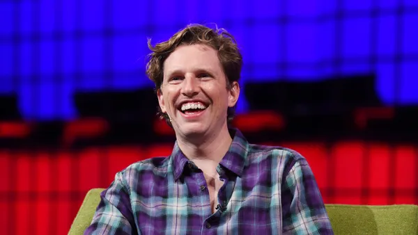 Man smiling on stage at tech event