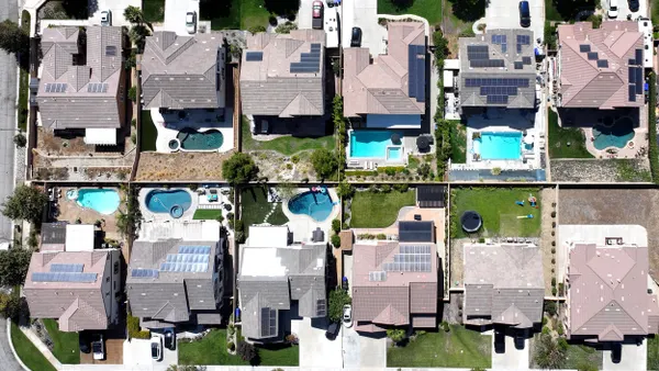 An aerial view of residential homes, many with solar panels.