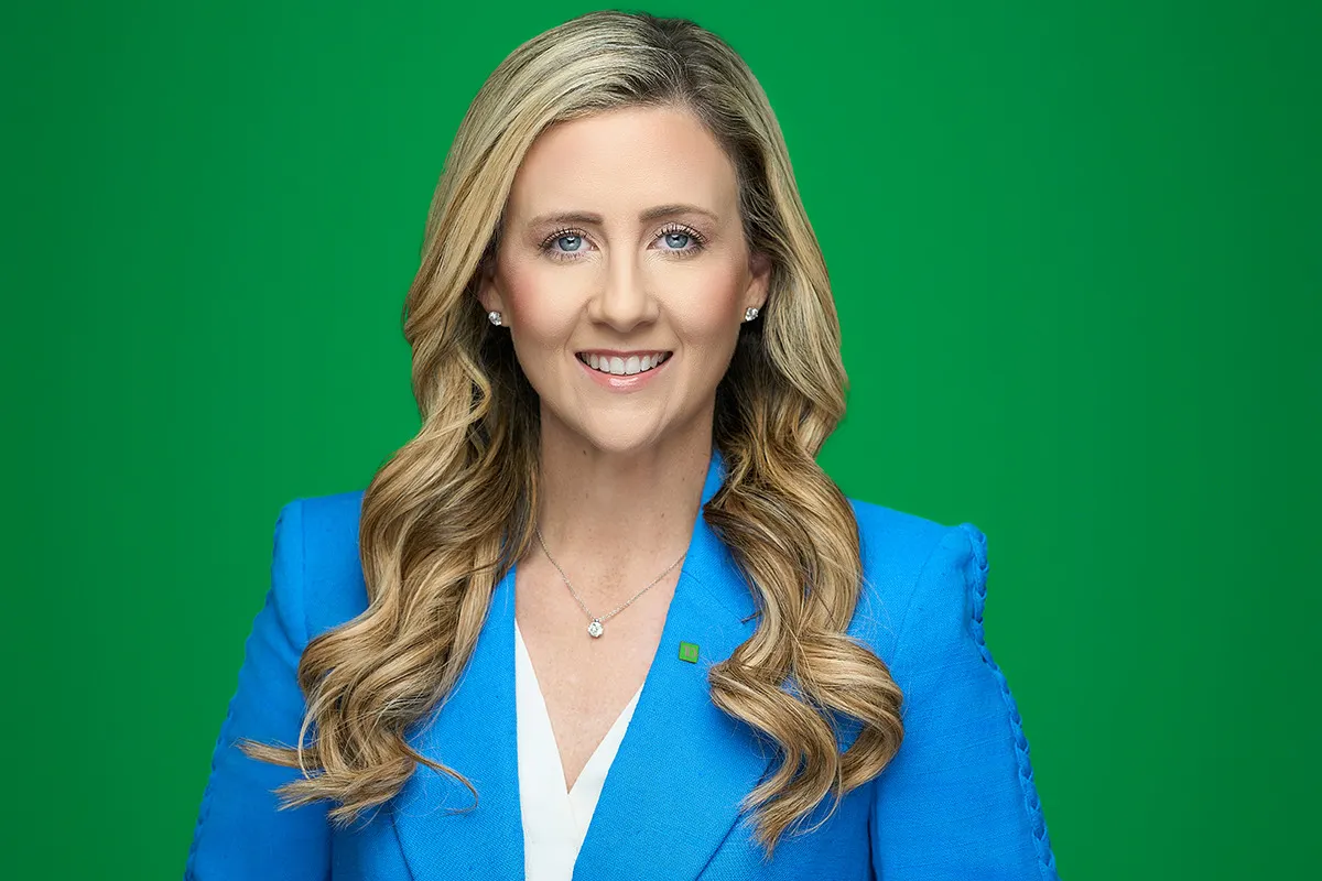 A person wearing a blazer smiles for the camera