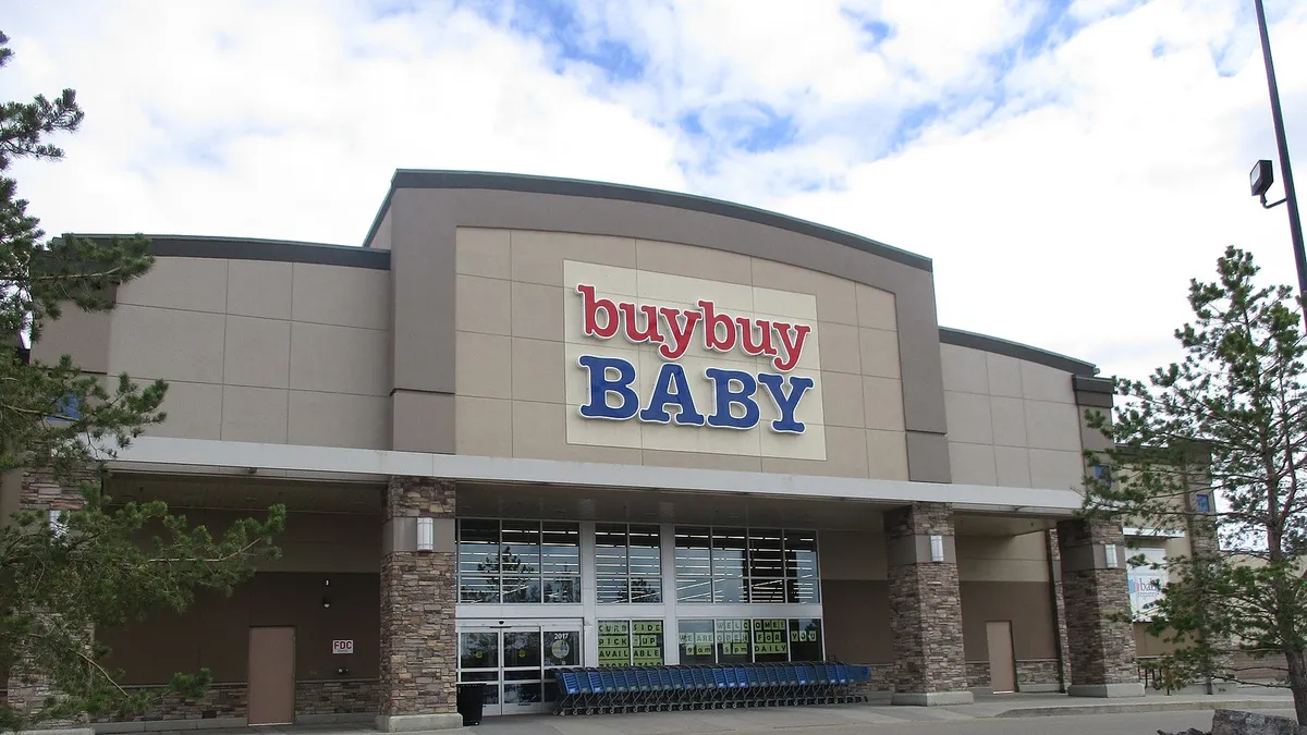 White clouds dominate in otherwise bright blue sky, above a "BuyBuy Baby" store.