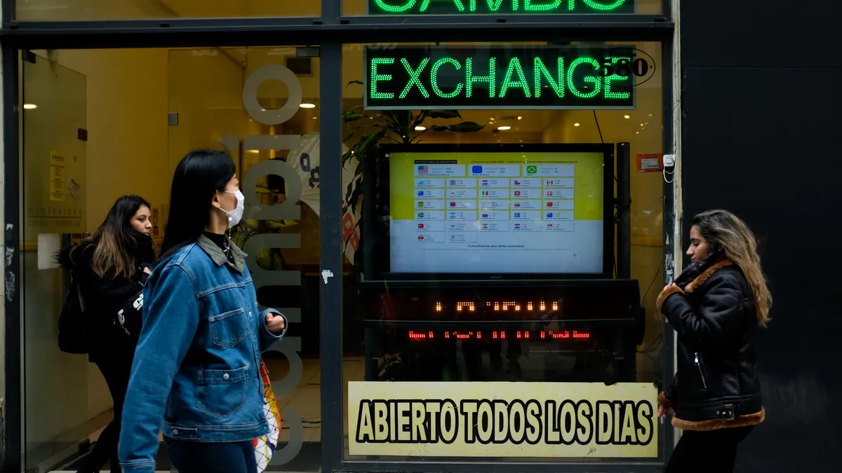 People walk by a currency exchange house in Buenos Aires, Argentina.