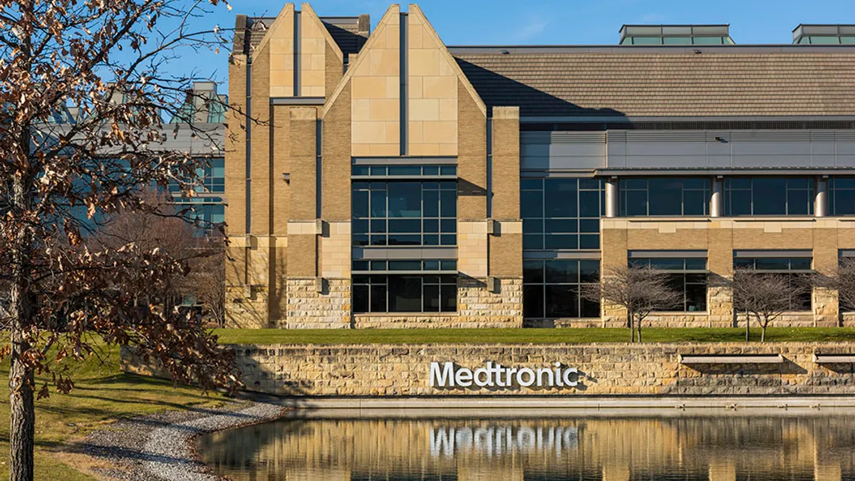 The exterior of Medtronic's Minnesota operational headquarters is shown along with its reflection in a pool of water.