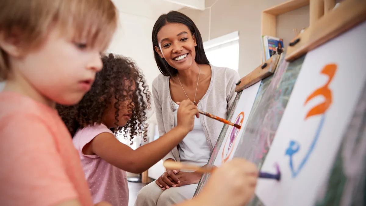 Teacher At Montessori School Helping Children in Art Class