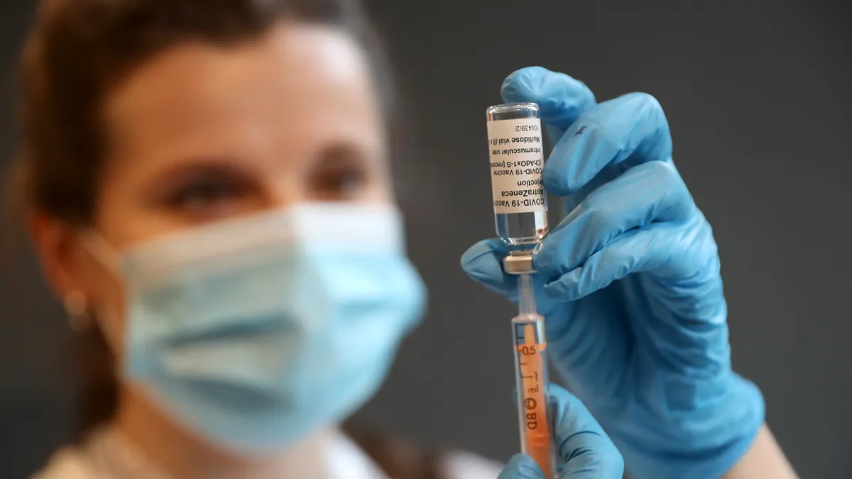 A clinical pharmacist prepares to administer a COVID-19 Vaccine.