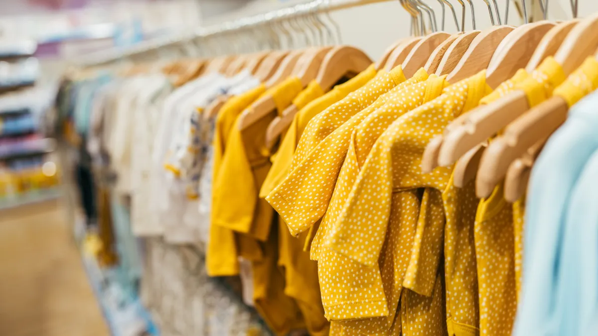 Close-up of children's clothing hanging on a store rack.