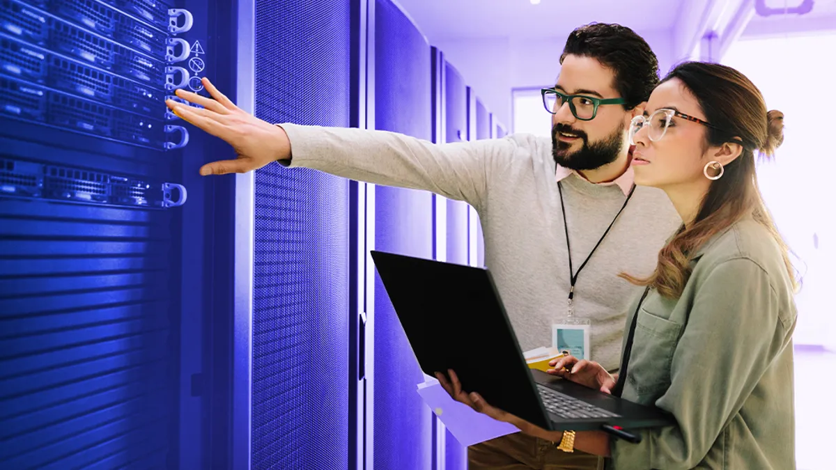 IT technicians examining equipment in network server room