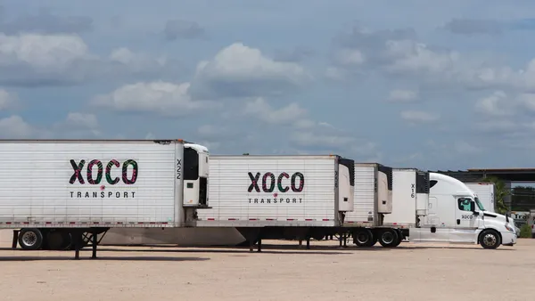 Xoco Transport refrigerated trailers in a lot with a tractor.