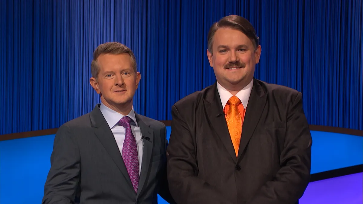 "Jeopardy!" host Ken Jennings and three-day champion Brian Henegar pose for a photo on the Alex Trebek stage.