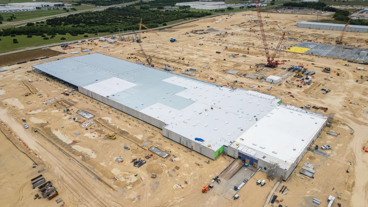 An aerial view of a construction site with cranes and construction vehicles.