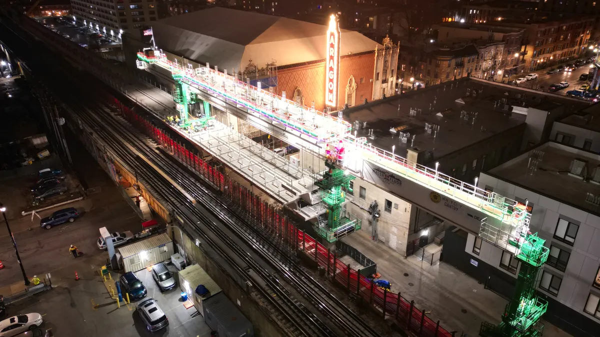 A large gantry for installing concrete is lit up for the holidays against a night backdrop in Chicago.