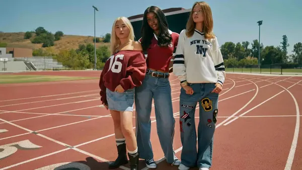 Three teens standing on an outdoor track.