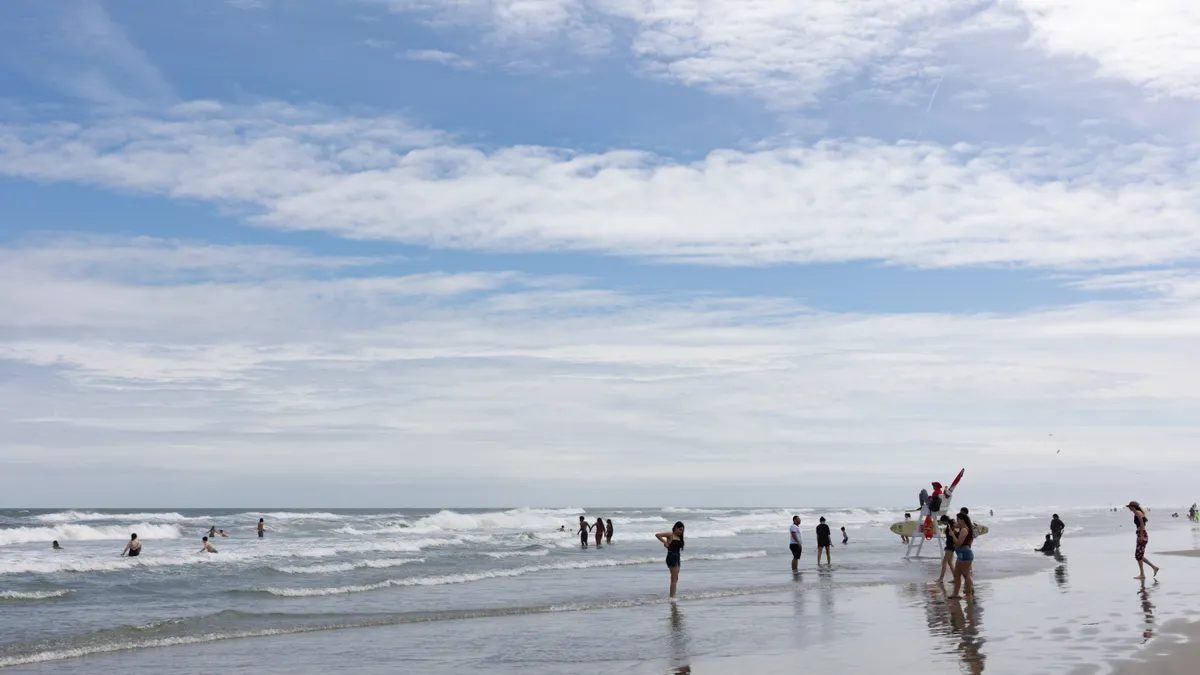 A group of people swim and play at a beach as a lifeguard watches in Wildwood, New Jersey, during Memorial Day weekend in 2023.