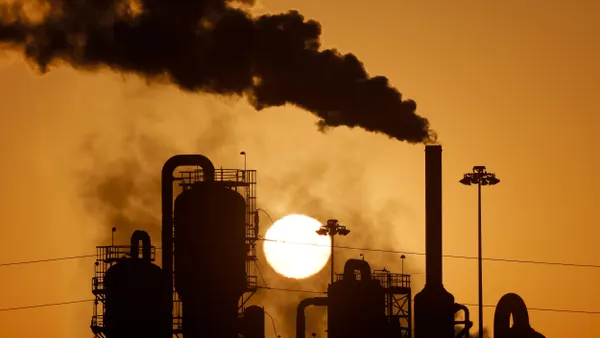 The sun behind a power plant