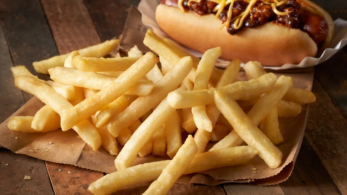 Lamb Weston's "Crispy on Delivery" fries are pictured next to a hot dog.