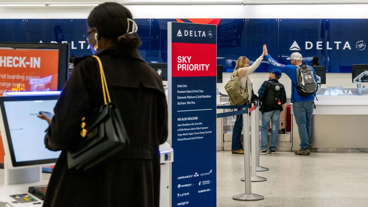 A woman checks in for her Delta flight at a kiosk.