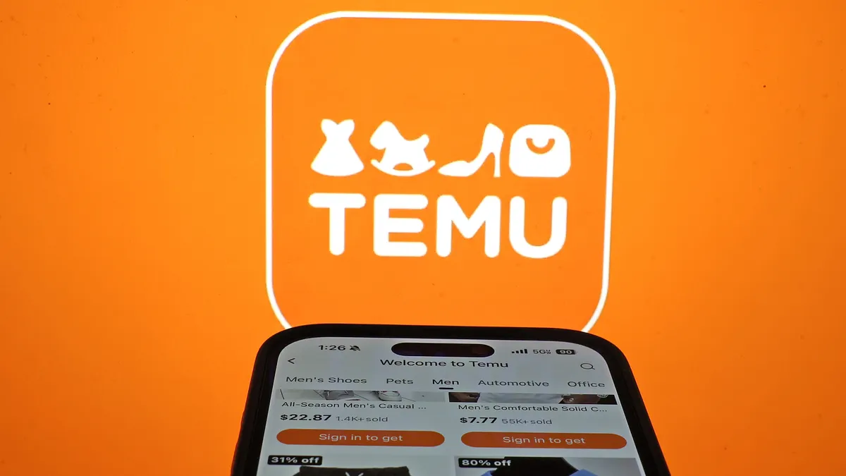 A person's phone is seen on the Temu app, against the Temu logo backdrop.