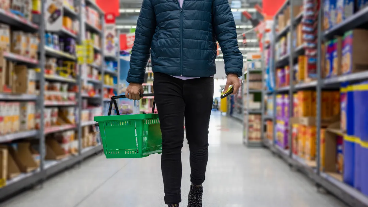 Low angle selected focus view of a person shopping in a supermarket while on a budget.