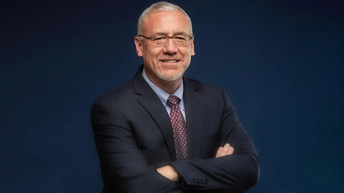 a headshot of mark ryland in business attire