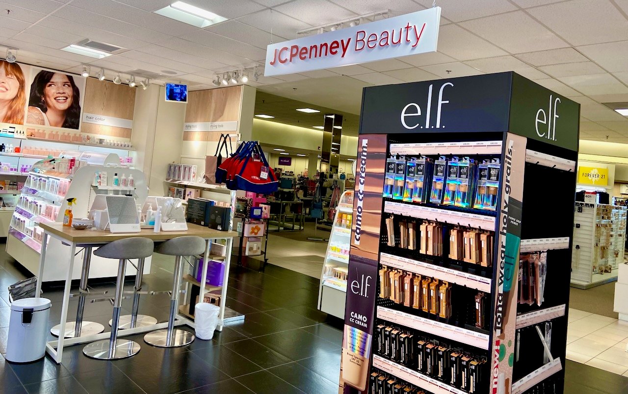 A space within a department store with beauty product displays, with an overhead sign reading "JC Penney Beauty."