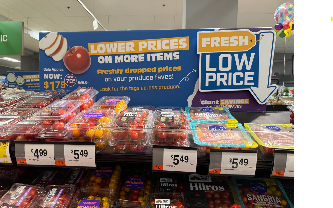 A sign advertising low prices for produce at a grocery store.