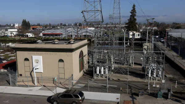 A view of a Pacific Gas & Electric (PG&E) electrical substation with a model power plug on the side of the building.