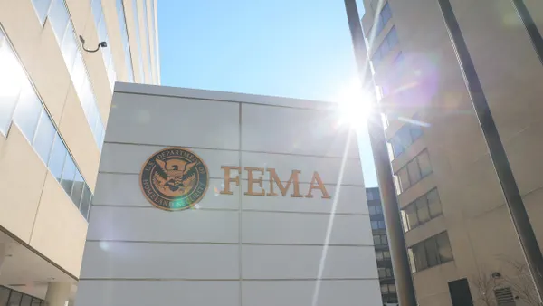 Sun rays behind a white building with a round seal and FEMA written on it.