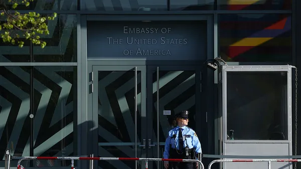 A sign reads 'Embassy of the United States of America.' The doors and windows are clear.