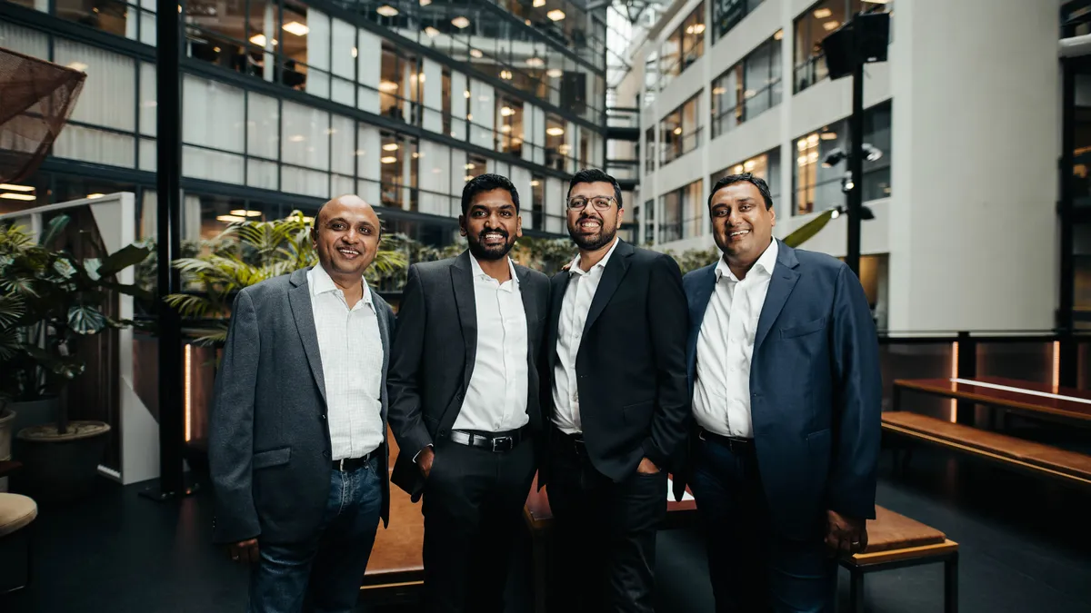 Four people stand for a professional headshot.