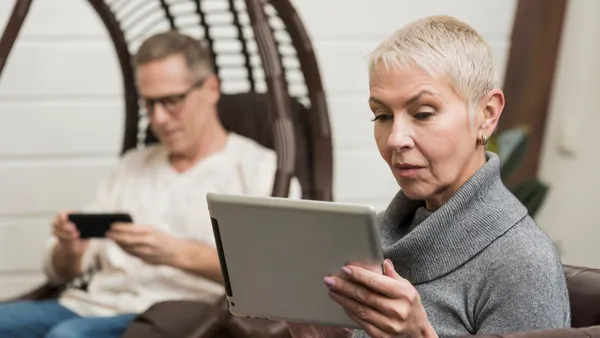 Woman sitting down looking on an iPad
