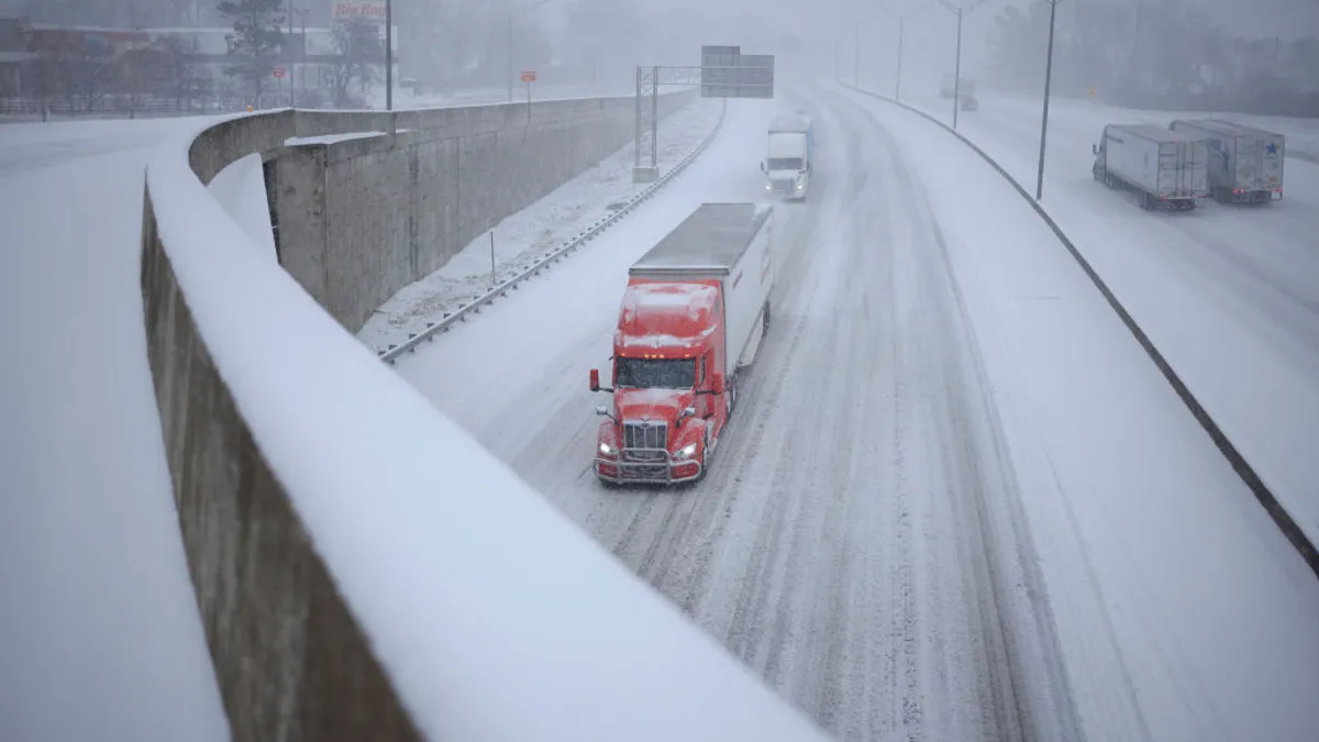 Semi trucks drive through the snow along I-264 on January 5, 2025 in Louisville, Kentucky.