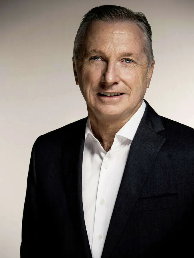 A man in a white shirt and black suit jacket