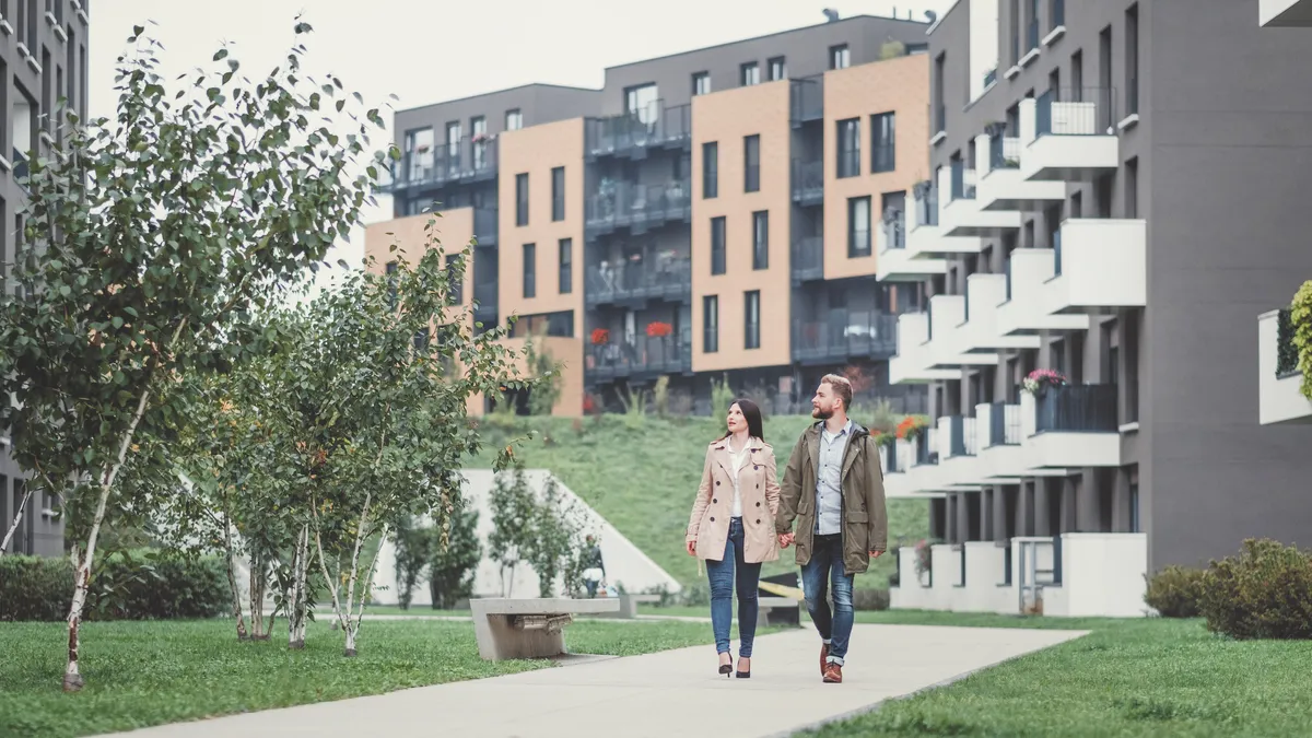 Couple looking for apartment. Image taken at average residential area with multiple ownership block of flats type of buildings.