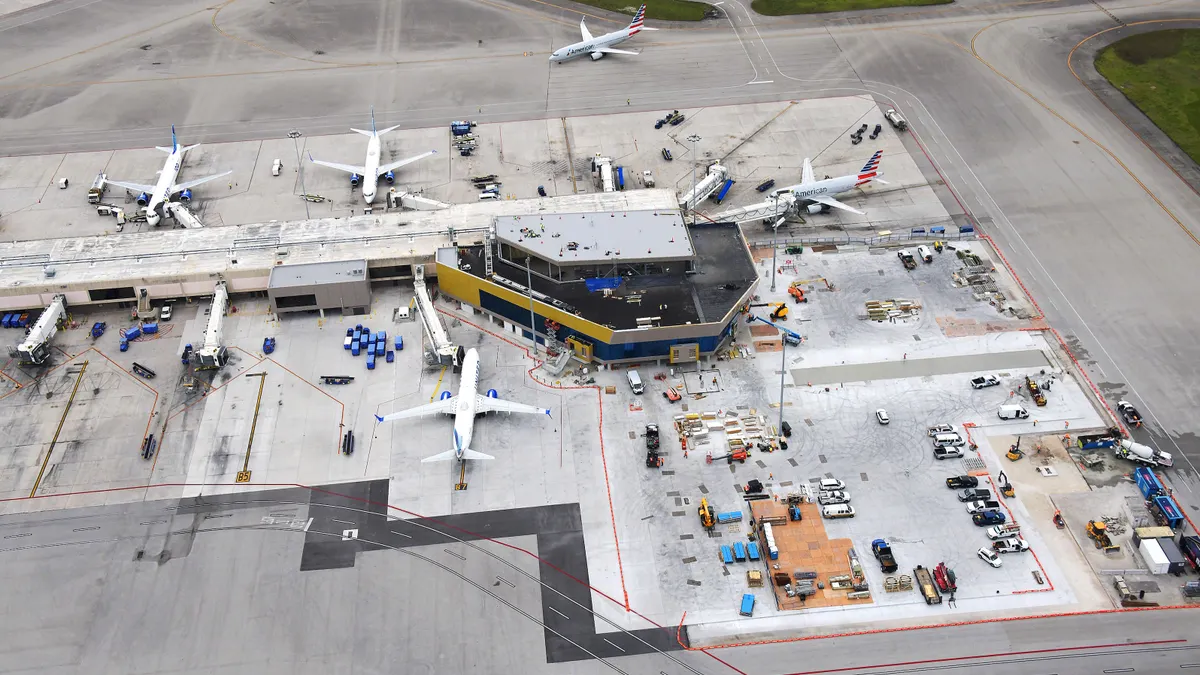 An aerial shot of an airport, with the camera overlooking the tarmac and planes.
