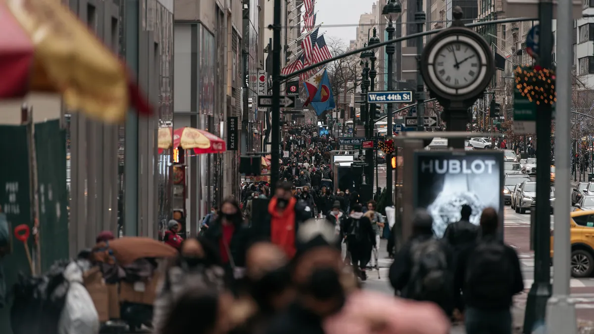 A group of people walk on a New York City street.