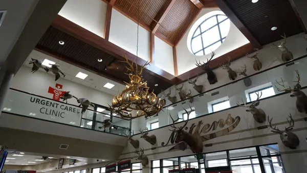 A photo of the interior of a travel center with several taxidermied animal heads on the walls. A sign on one wall says "Urgent care" and another says "Mittens"
