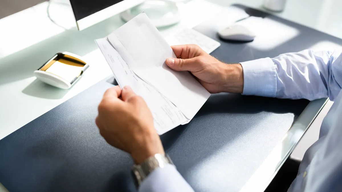 Person holding paycheck.