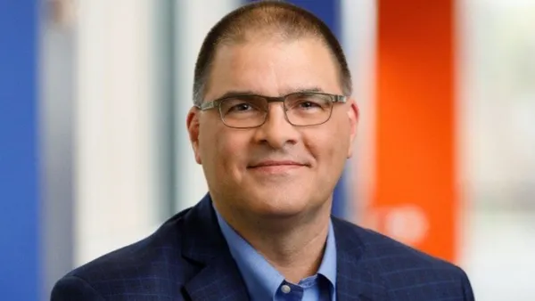 A close head-on view of a man wearing glasses.