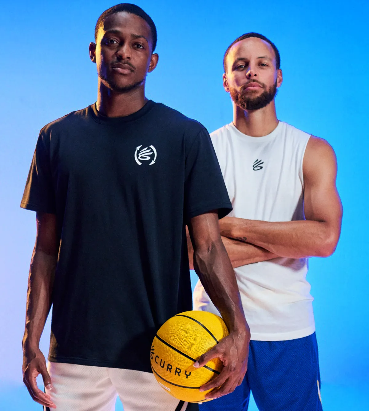 De'Aaron Fox and Steph Curry stand next to each other on a blue background.