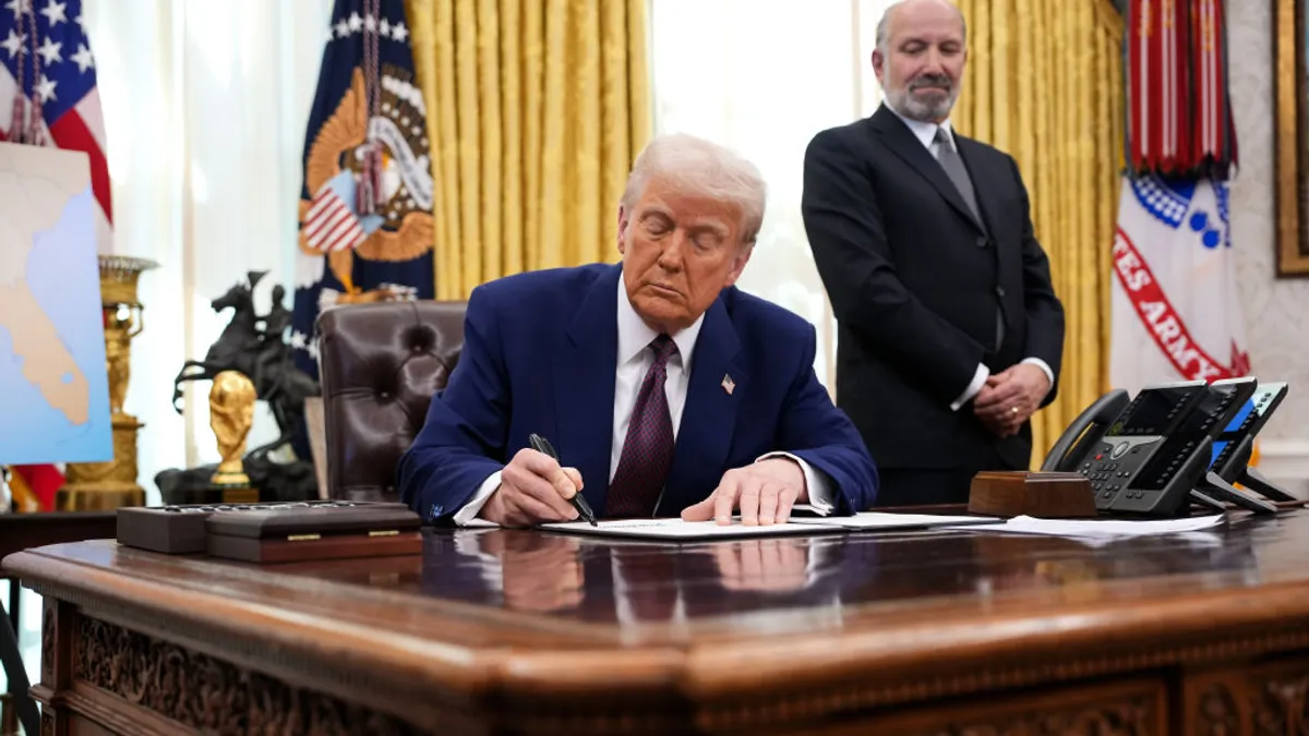 President Donald Trump, joined by Secretary of Commerce Howard Lutnick, signs an executive order on reciprocal tariffs in the Oval Office at the White House on Feb. 13, 2025 in Washington, DC