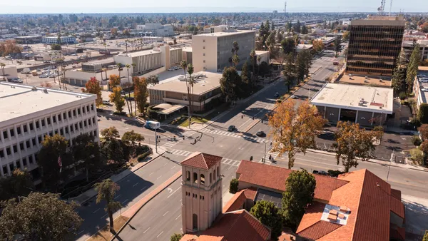 Aerial shot of intersection surrounded by buildings and trees.