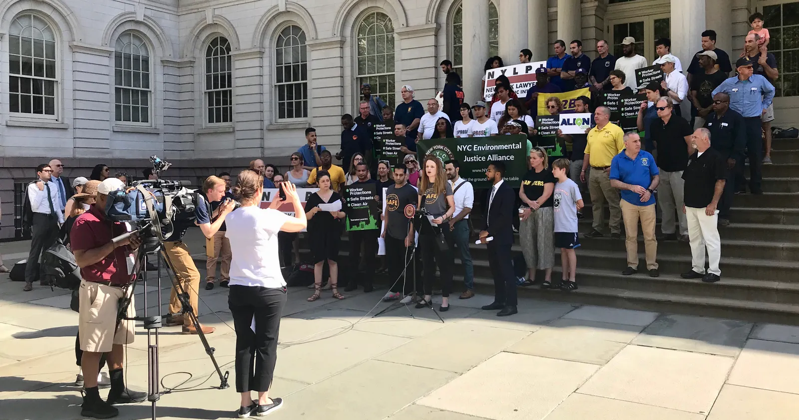 A group of people rally on the steps of New York City Hall