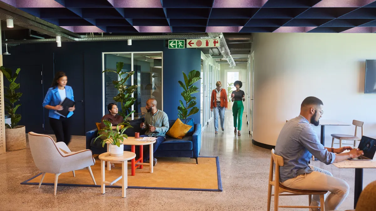 A group of worker in a lounge area of a modern office space.