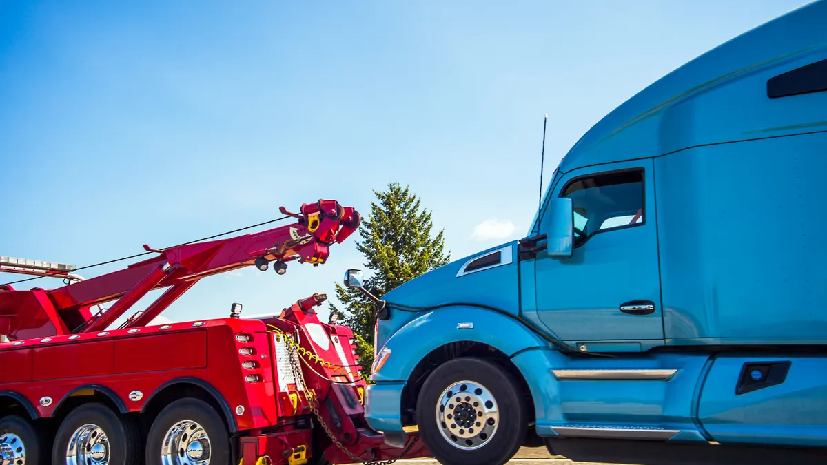 A tow truck pulls a blue semi truck in the Seattle area.